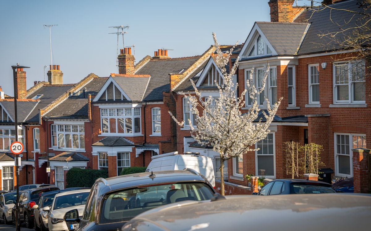 Row of red-brick terraced houses on a residential street in England